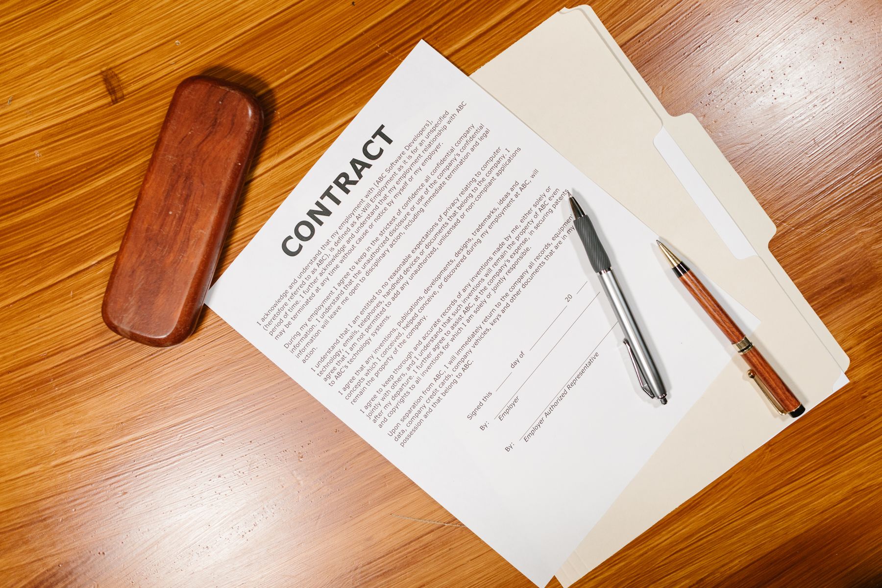Contrat imprimé posé sur un bureau avec un stylo.